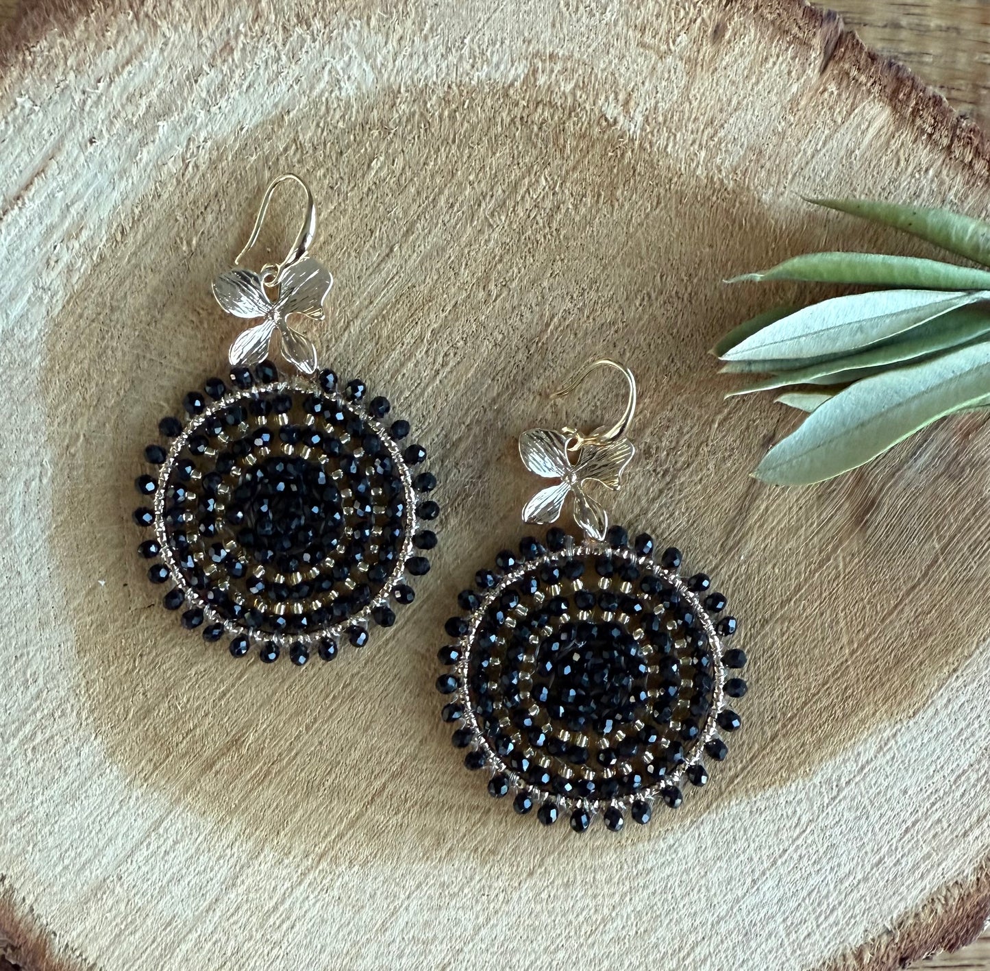 Zwarte kralen aan een bloemetje.