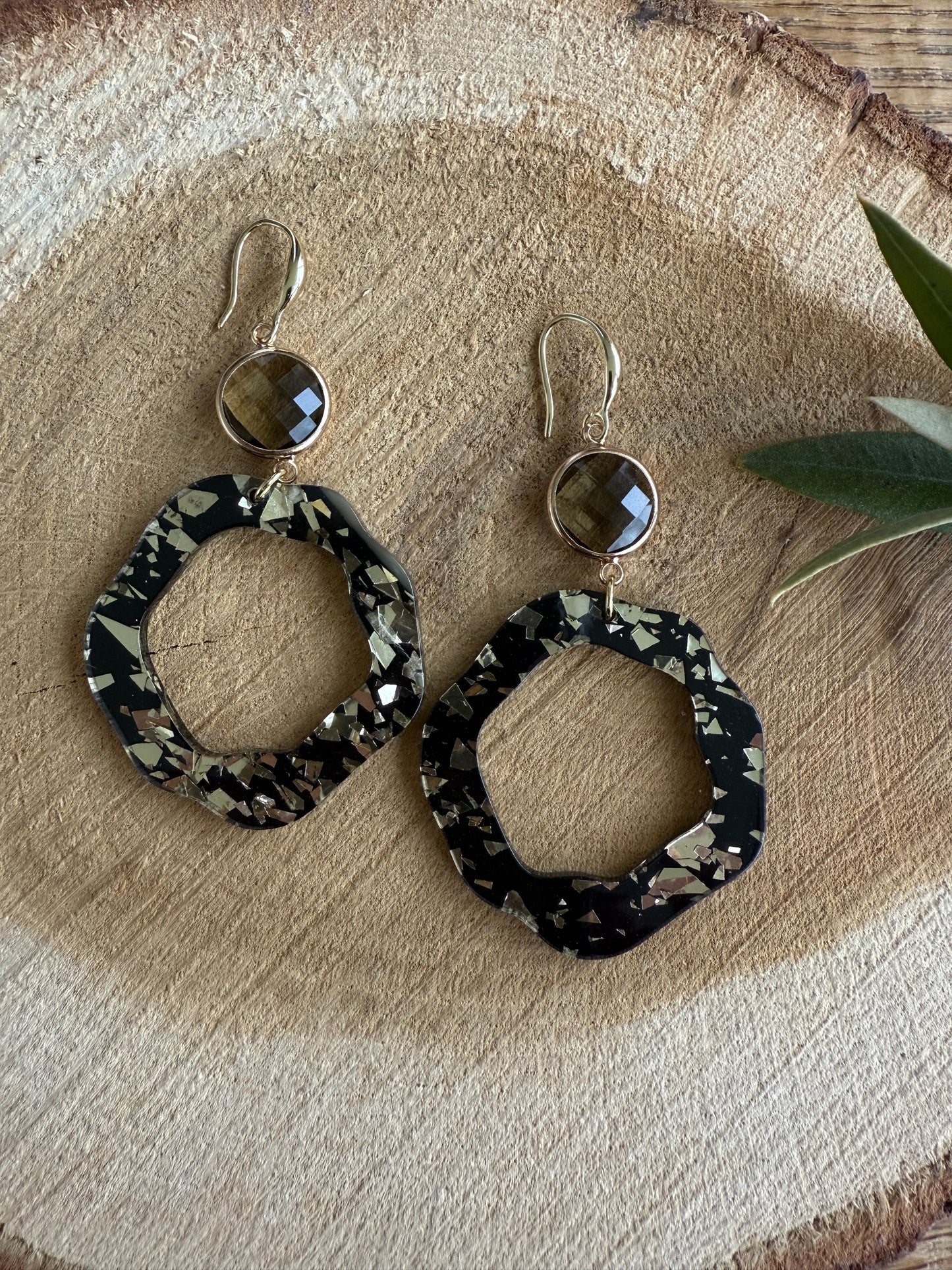 Doorzichtige bruine facetsteen met zwart/bladgouden resinhanger