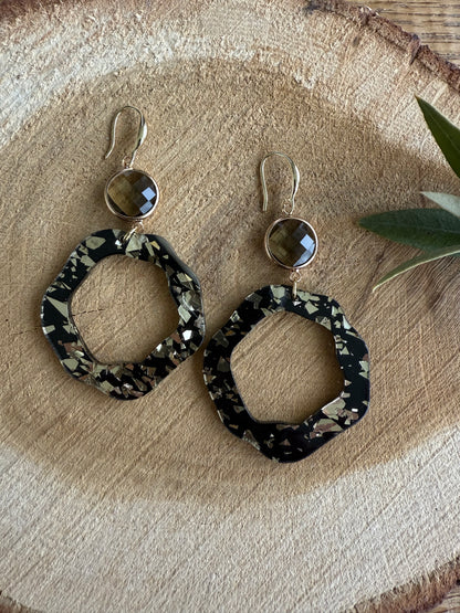 Doorzichtige bruine facetsteen met zwart/bladgouden resinhanger