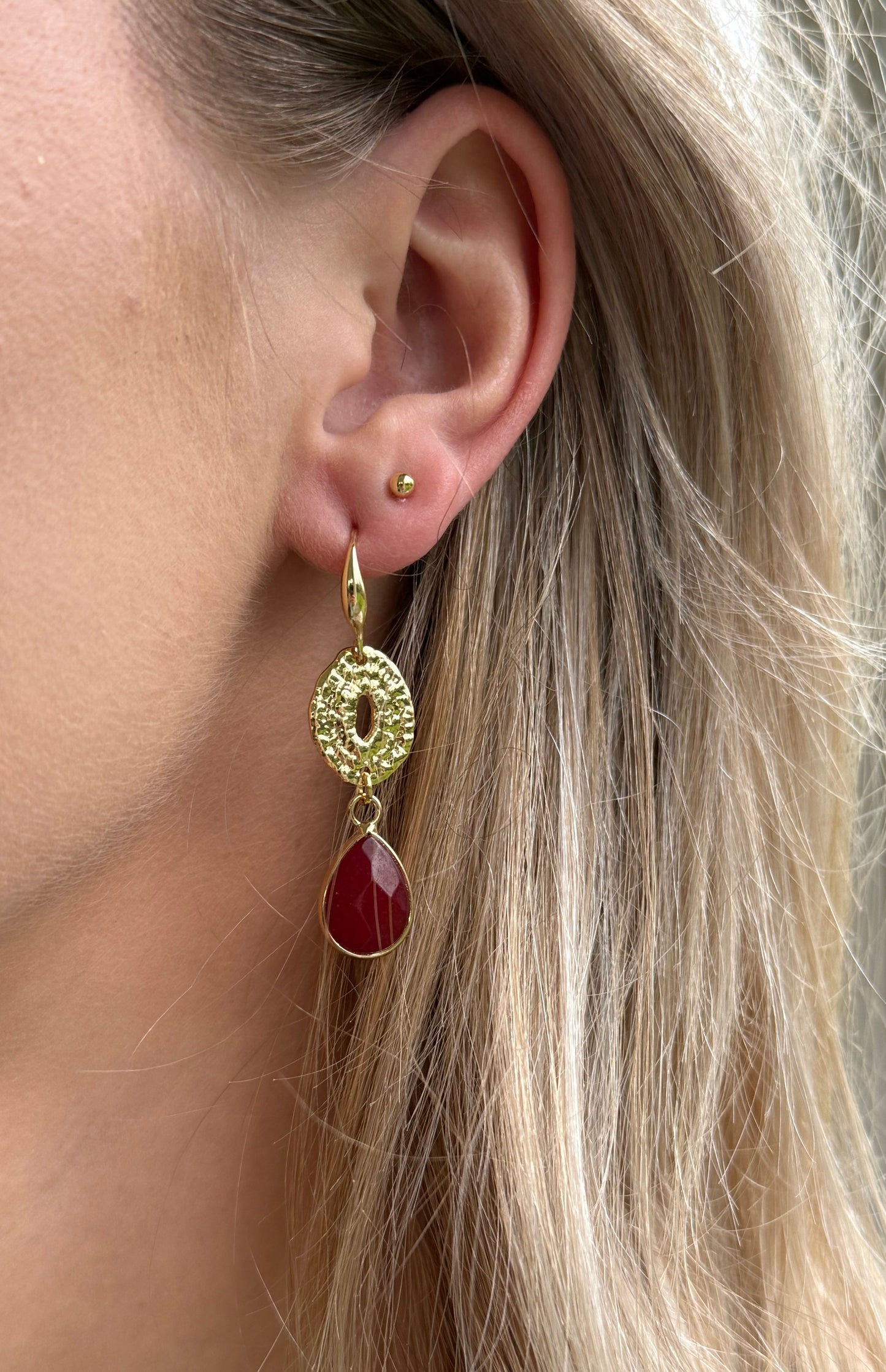 Kleine bordeauxrode natuursteen druppel aan een dichte connector